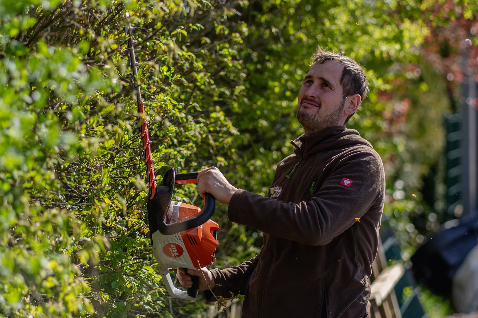 Mitarbeiter von Meistergärtner Meiser schneidet eine Hecke mit der Akku-Heckenschere